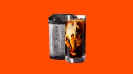 一个黑色的HyperChiller饮料冷却器和一杯在橙色背景下的冰咖啡。